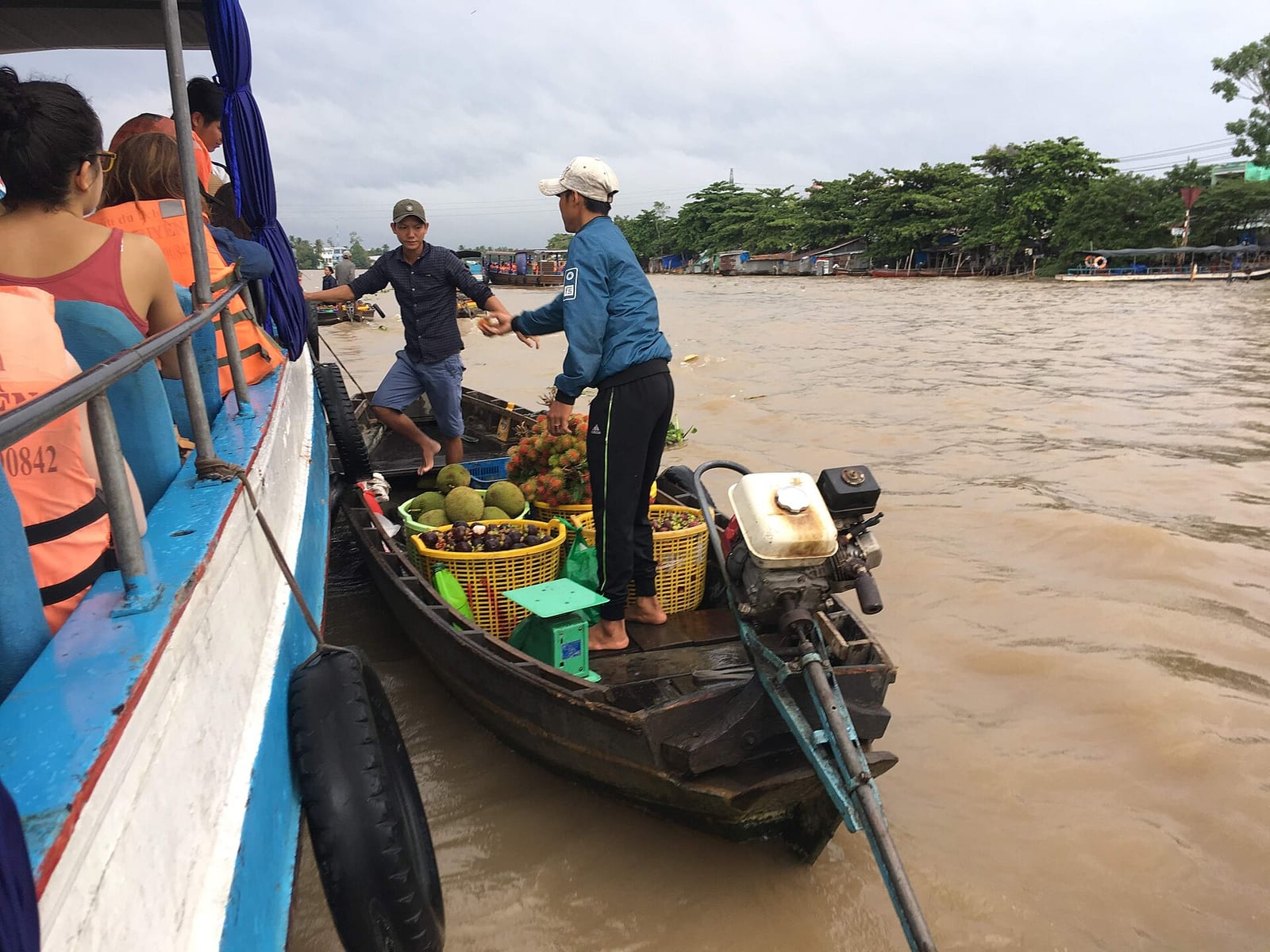 Fruit being passed between boats at Cai Rang floating market