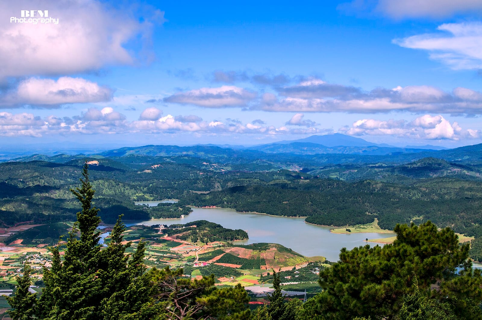 View over pine forest, farmland and a reservoir lake from the Langbiang plateau near Da Lat