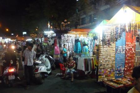 A busy night-market street lined with stalls and lights